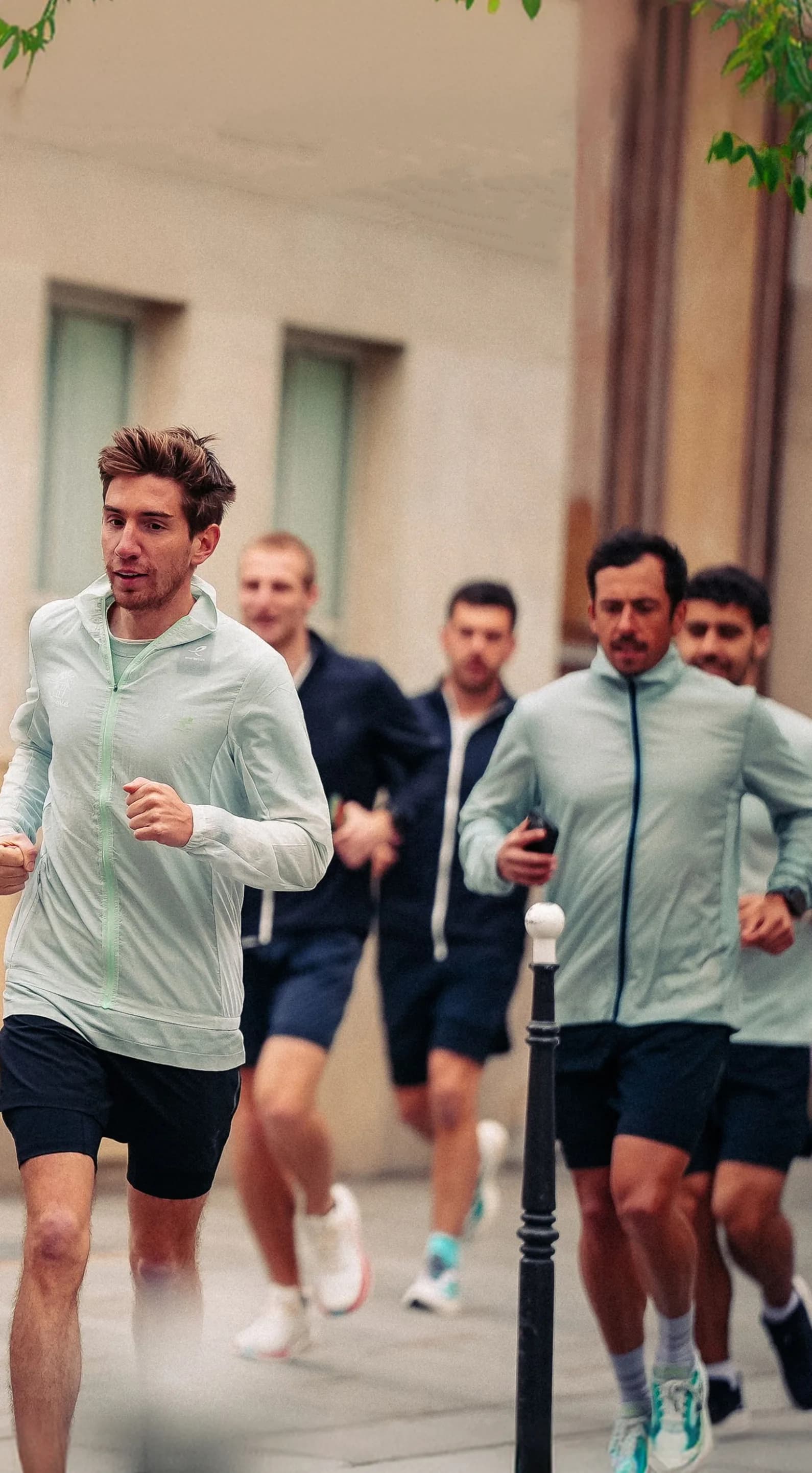 Un groupe de coureurs en pleine foulée dans une rue parisienne